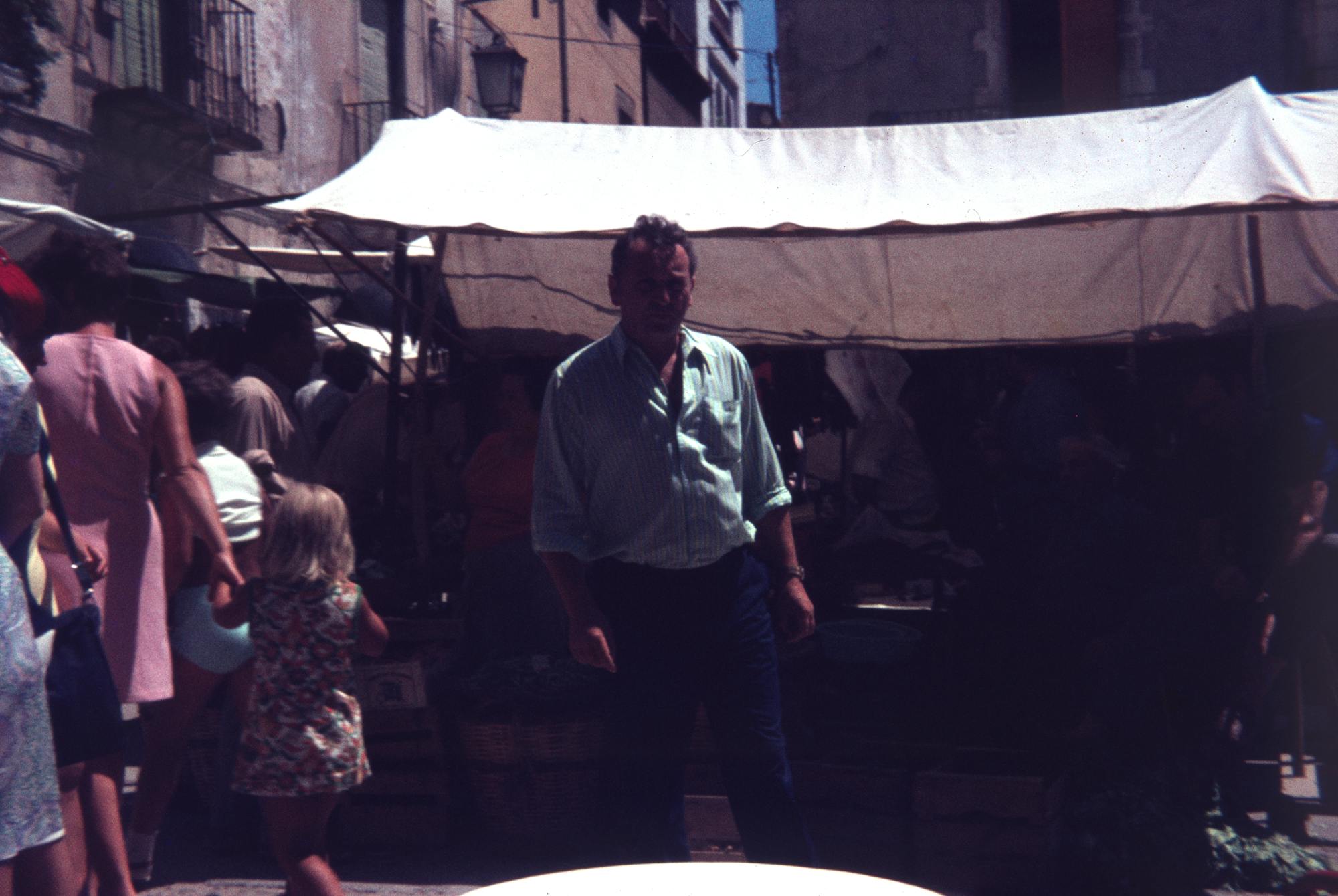 A man posing at a outside market, a slide from bigkkids'zine