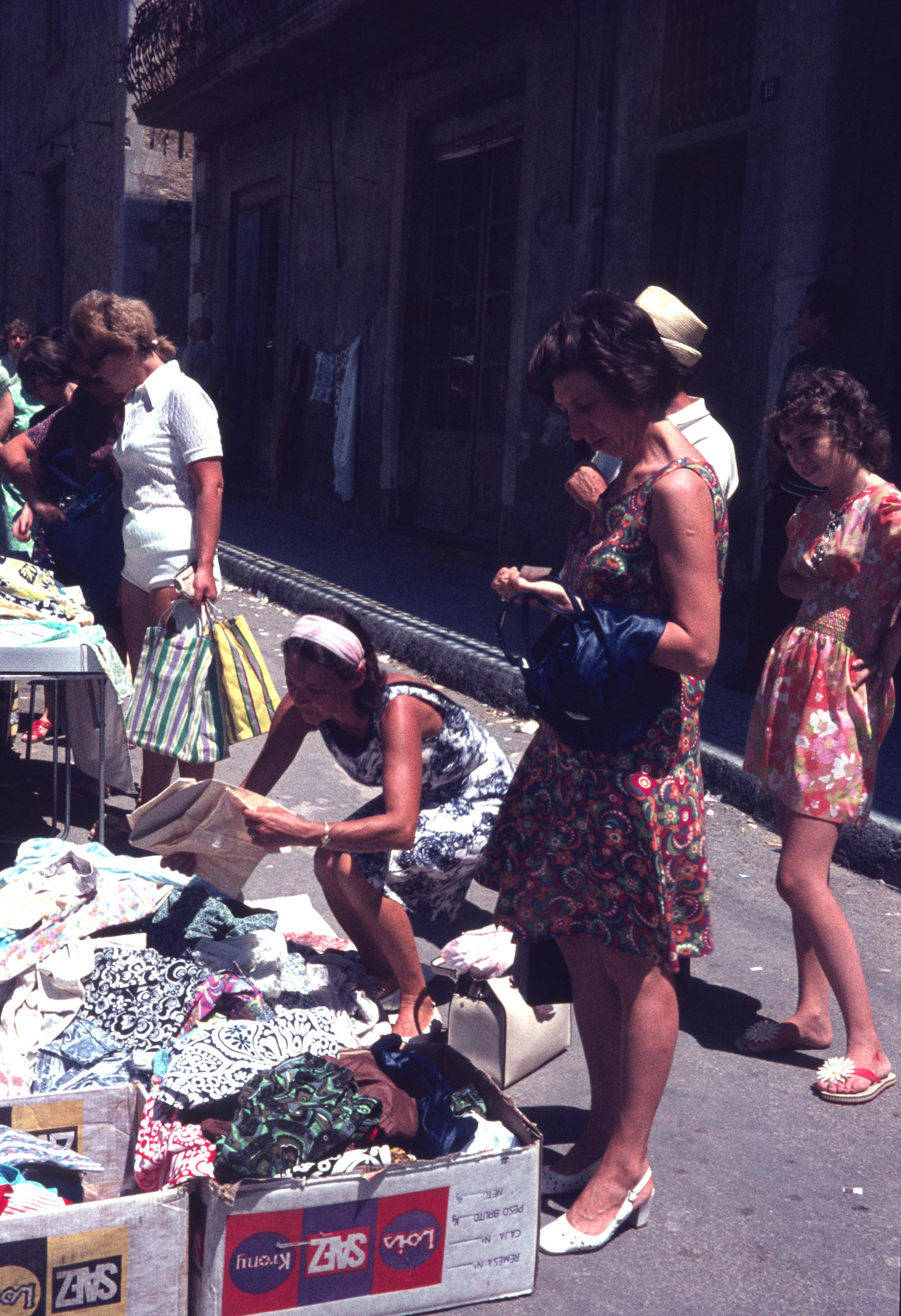 A group of people looking at a pile of clothes, a slide from bigkkids'zine